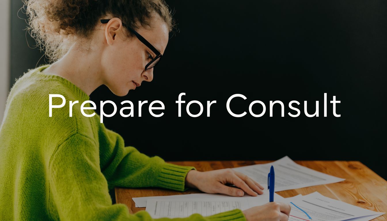 A woman with glasses sitting at a desk and taking notes on legal documents for a consultation.